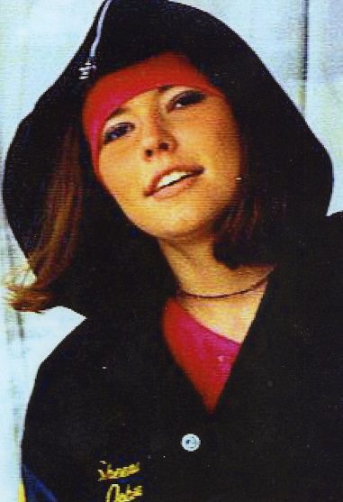 A woman wearing a black hooded jacket and red shirt