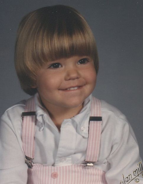 A young boy with short hair and pink suspenders