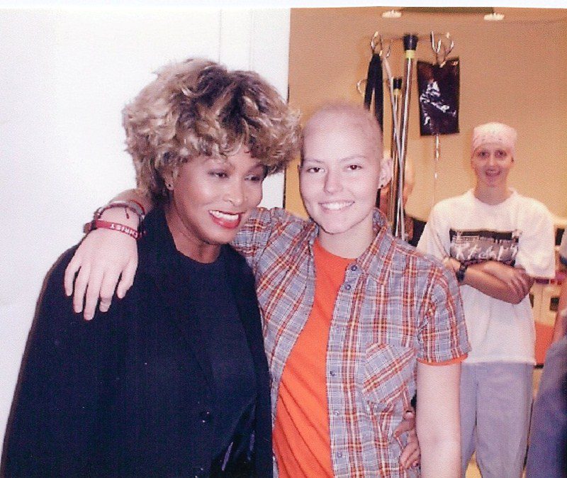 A woman with her head shaved and another woman in black