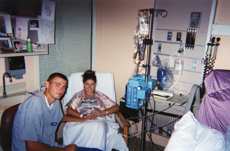 A man and woman sitting in a hospital bed